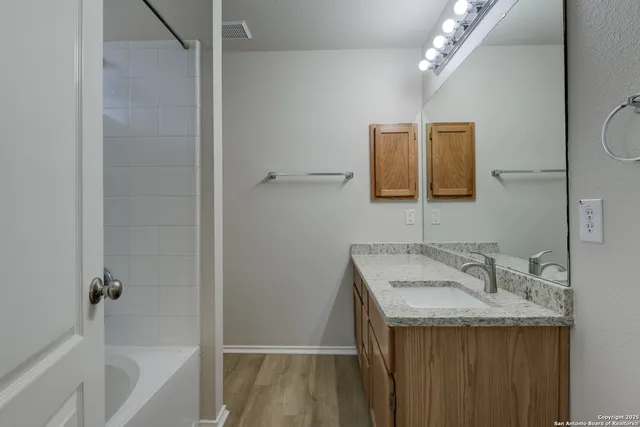 a bathroom with a granite countertop sink and a mirror