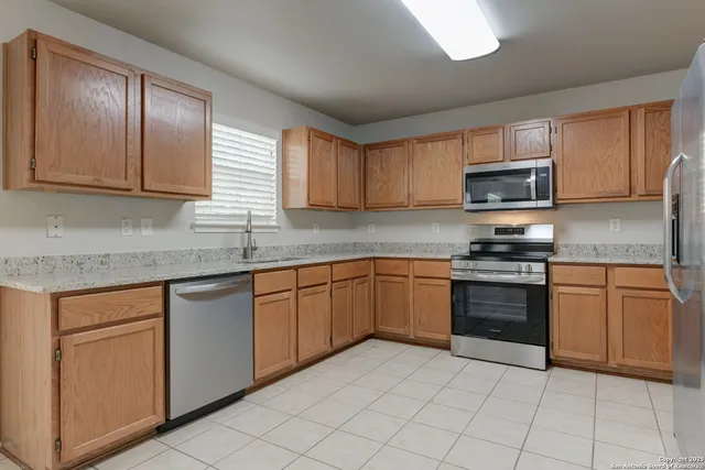 a kitchen with cabinets appliances and a sink