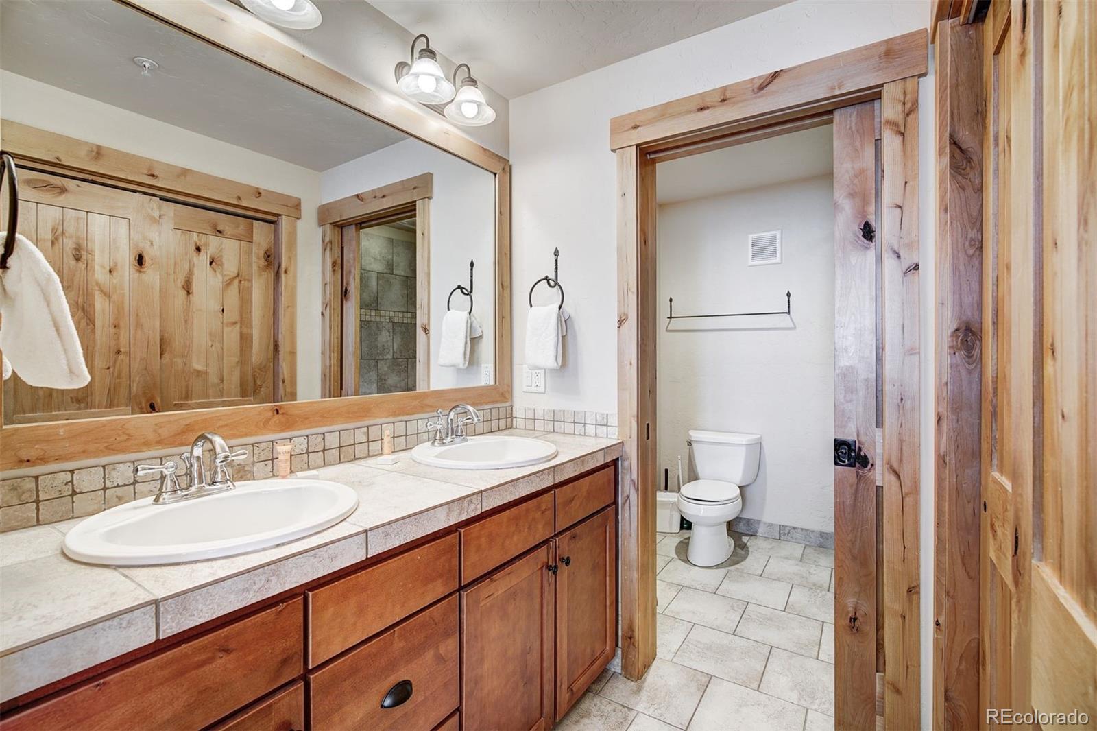 35 Tip Top Trail, Unit 6500 Keystone, CO 80435 - Photo 14 of 24 a bathroom with a granite countertop sink a toilet and a mirror