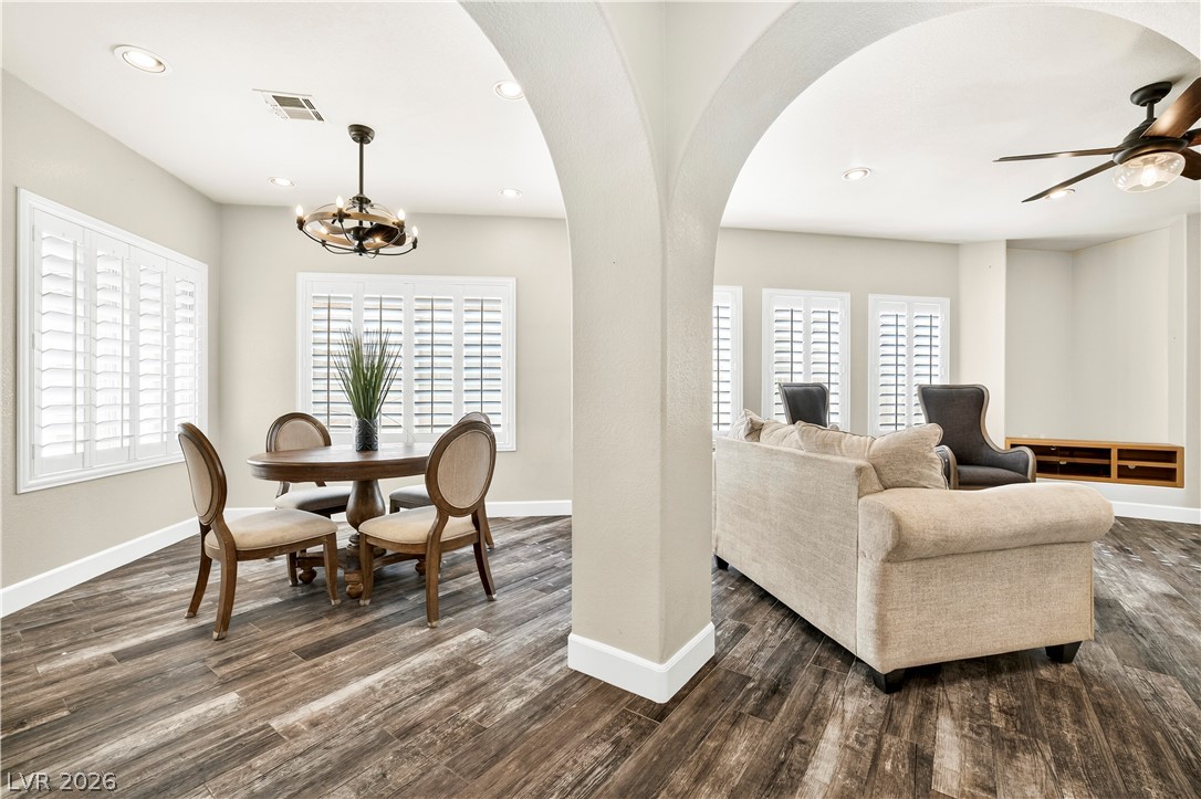 1135 Calico Ridge Drive Henderson, NV 89011 - Photo 13 of 86 Arched architectural details delineate an inviting, open-concept living and dining area with rich wood-look porcelain tile flooring.