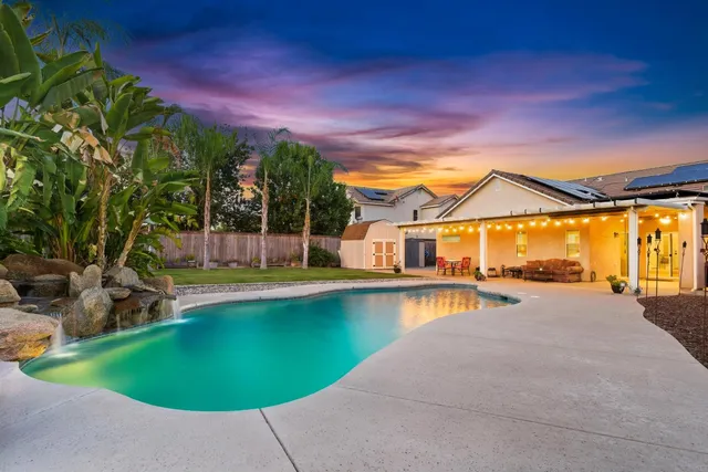 a view of a house with swimming pool and sitting area