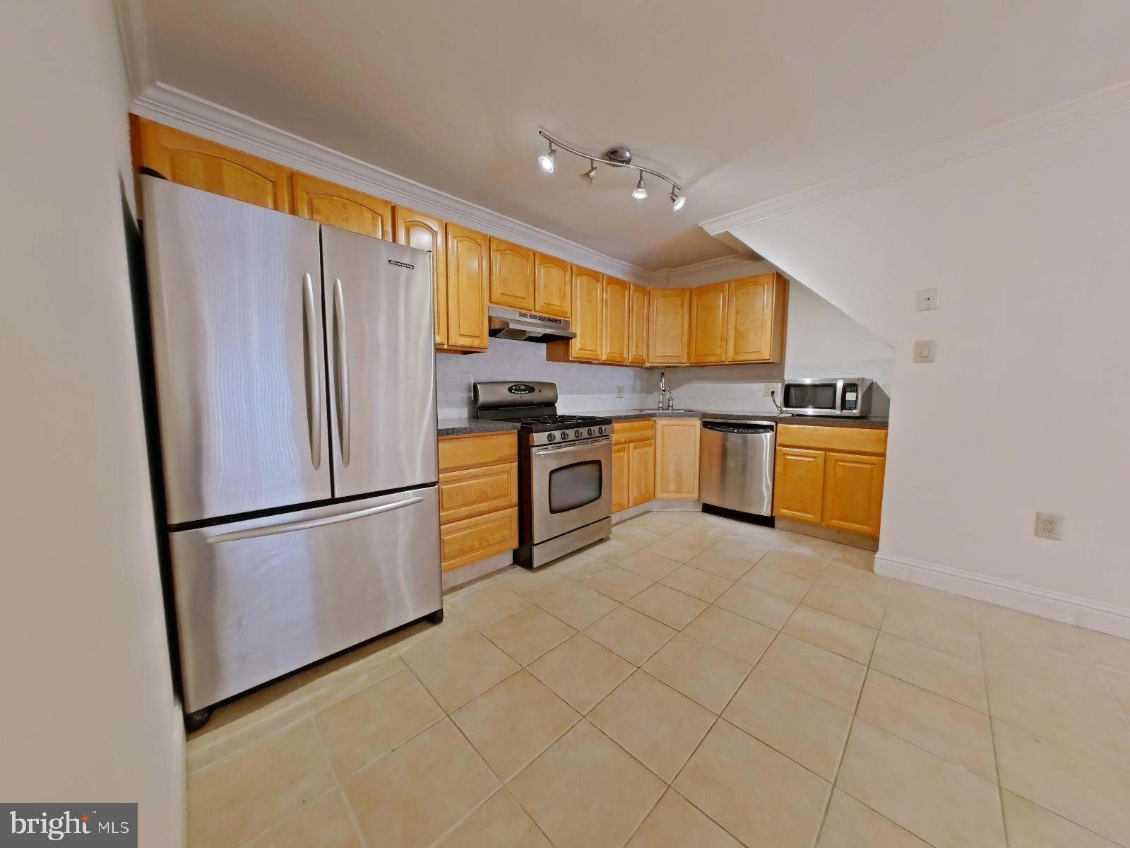 610-12 Bainbridge Street, Unit 2 Philadelphia, PA 19147 - Photo 12 of 23 a kitchen with stainless steel appliances granite countertop a refrigerator a stove a sink and a microwave