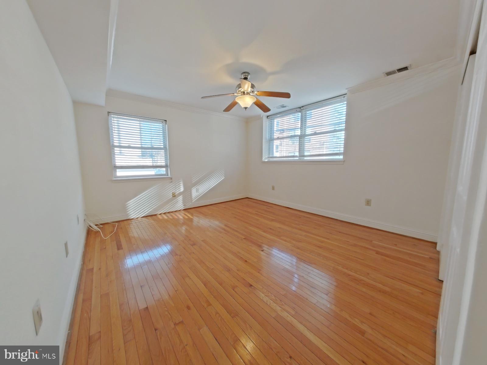 610-12 Bainbridge Street, Unit 2 Philadelphia, PA 19147 - Photo 13 of 23 an empty room with wooden floor ceiling fan and windows