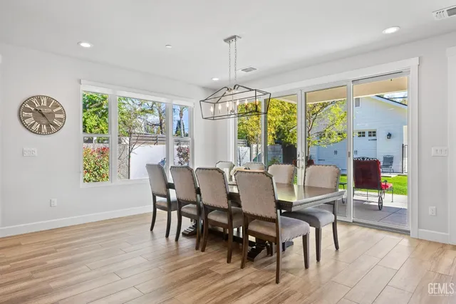a kitchen with stainless steel appliances a stove a white cabinets and a wooden floor