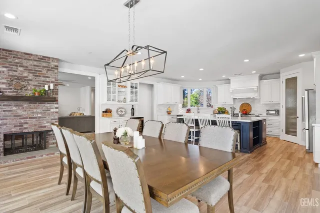 a large kitchen with kitchen island a large counter top appliances and cabinets