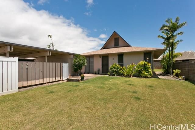 a front view of a house with a yard and potted plants