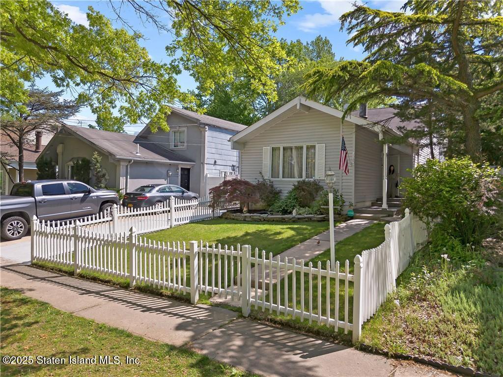 1182 Arthur Kill Road Staten Island, NY 10312 - Photo 2 of 3 a view of a house with a small yard and a large tree
