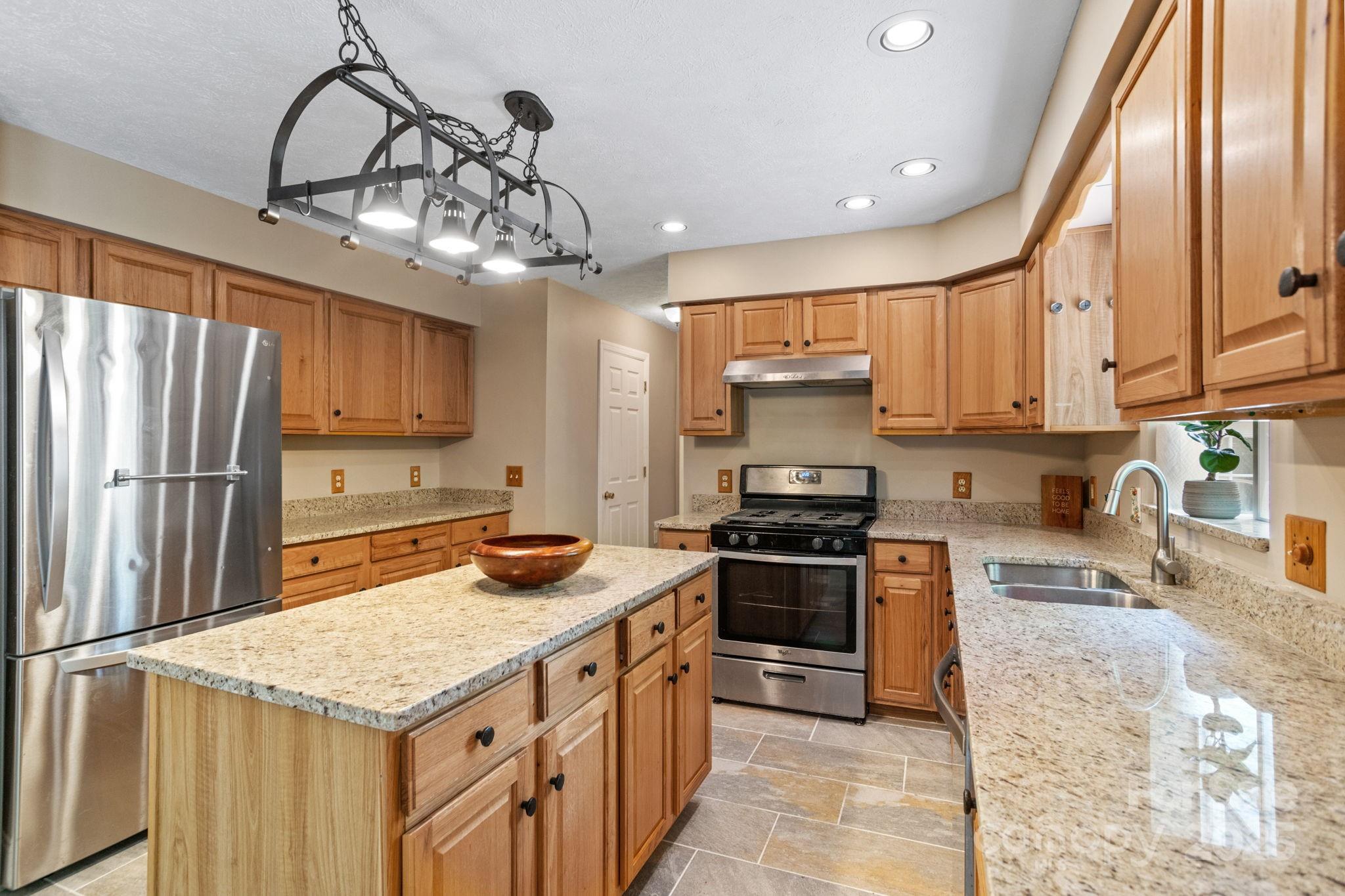 55 Vintage Road Candler, NC 28715 - Photo 11 of 47 a kitchen with stainless steel appliances granite countertop a sink stove refrigerator and cabinets