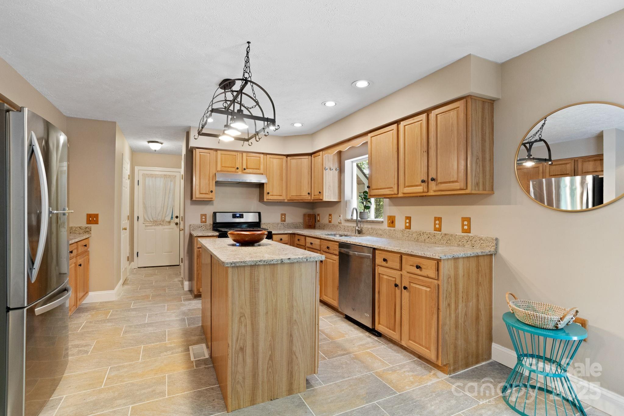 55 Vintage Road Candler, NC 28715 - Photo 12 of 47 a kitchen with stainless steel appliances granite countertop a sink stove and refrigerator
