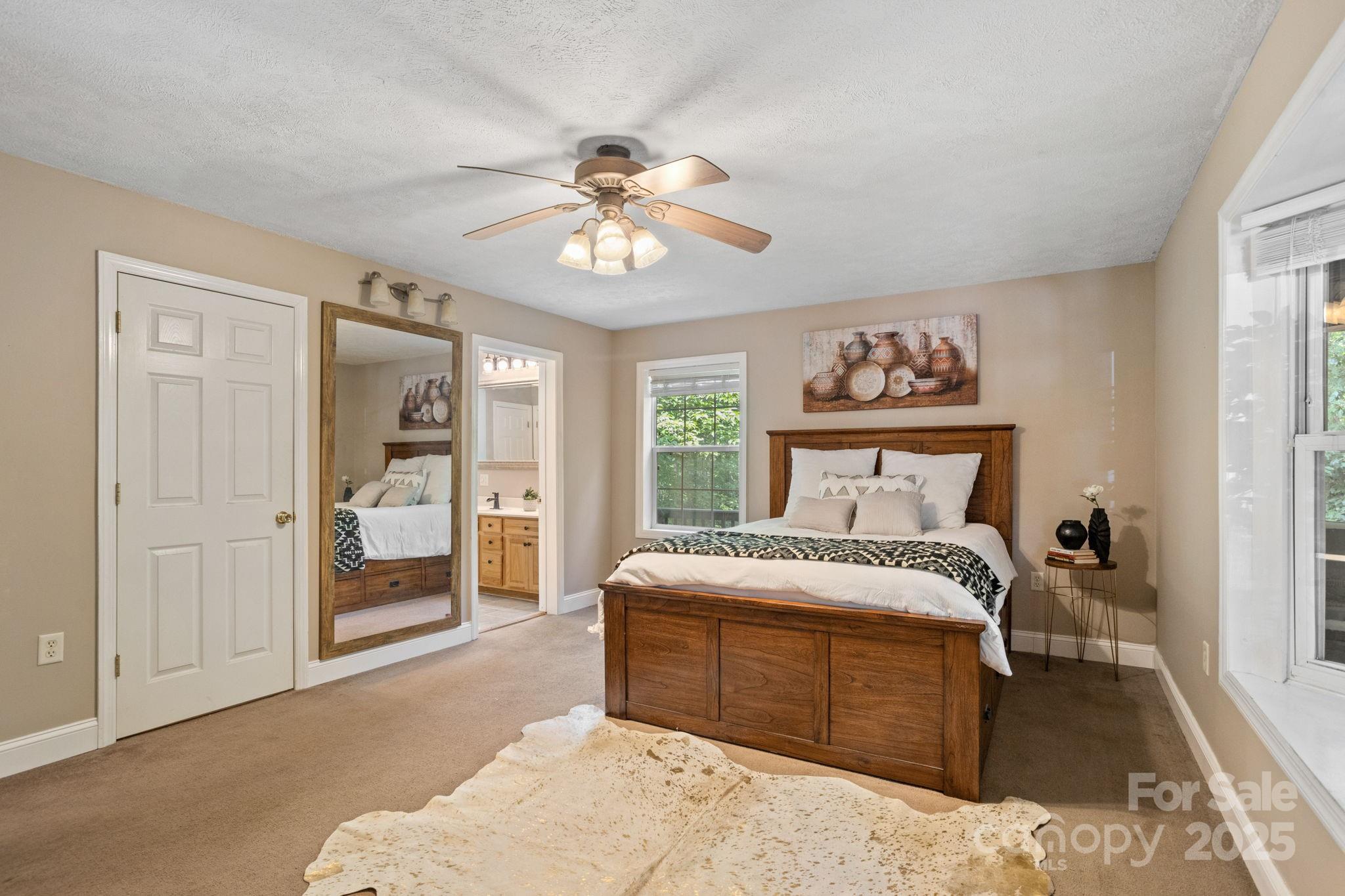 55 Vintage Road Candler, NC 28715 - Photo 15 of 47 a bedroom with a large bed and a chandelier