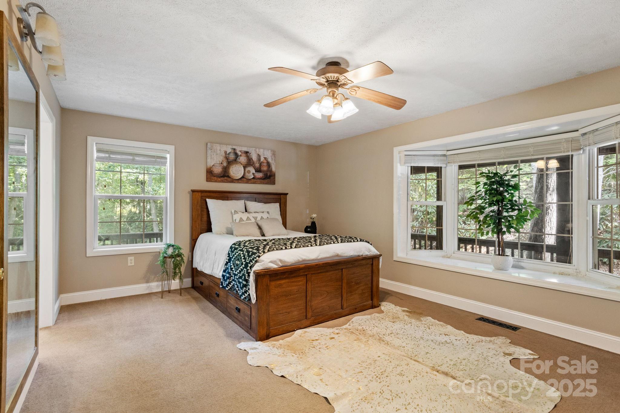 55 Vintage Road Candler, NC 28715 - Photo 16 of 47 a spacious bedroom with a large bed and a window
