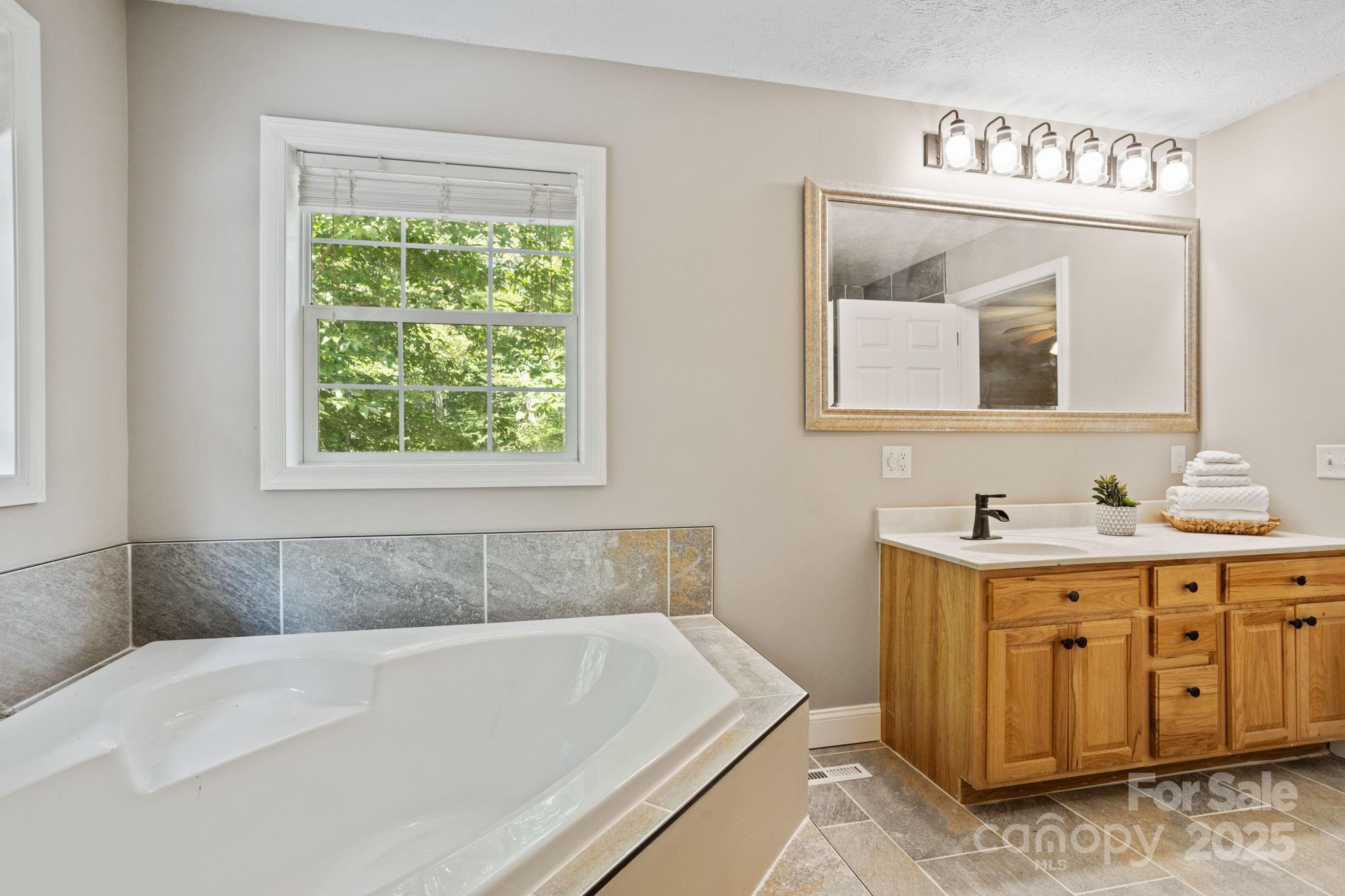 55 Vintage Road Candler, NC 28715 - Photo 18 of 47 a bathroom with a bathtub and a sink
