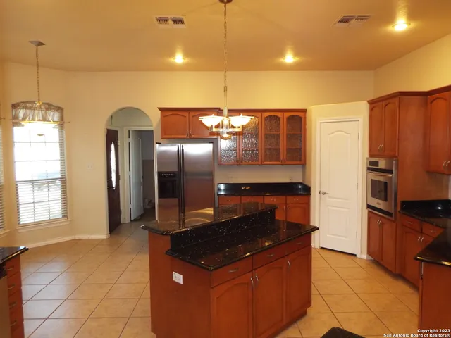a kitchen with stainless steel appliances granite countertop a sink and a refrigerator