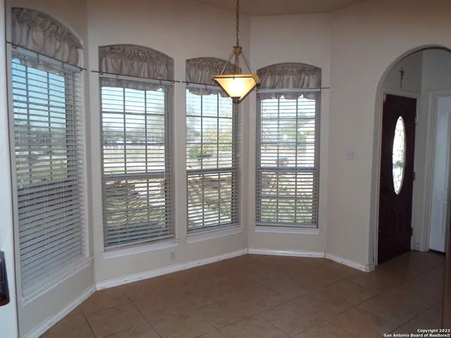 a view of empty room with window and chandelier