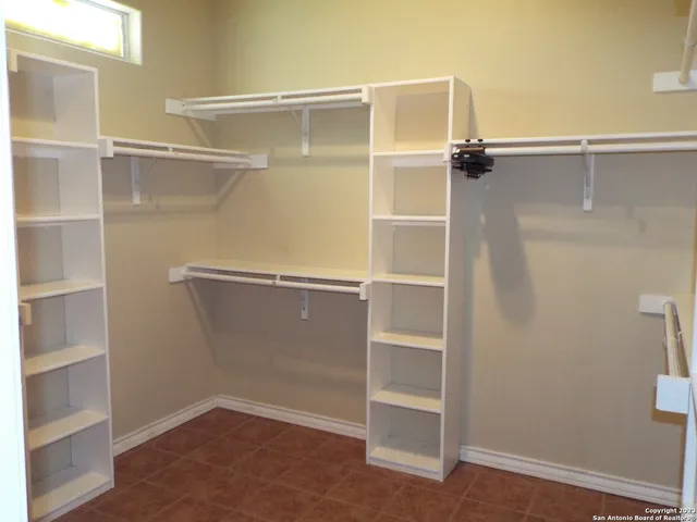 a view of walk in closet with empty racks