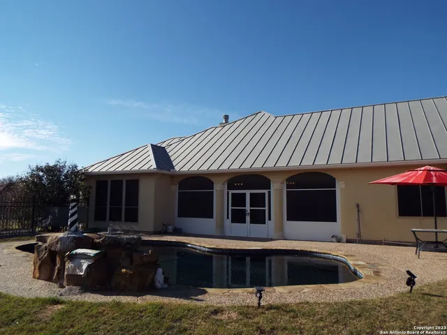 a swimming pool with outdoor seating and yard