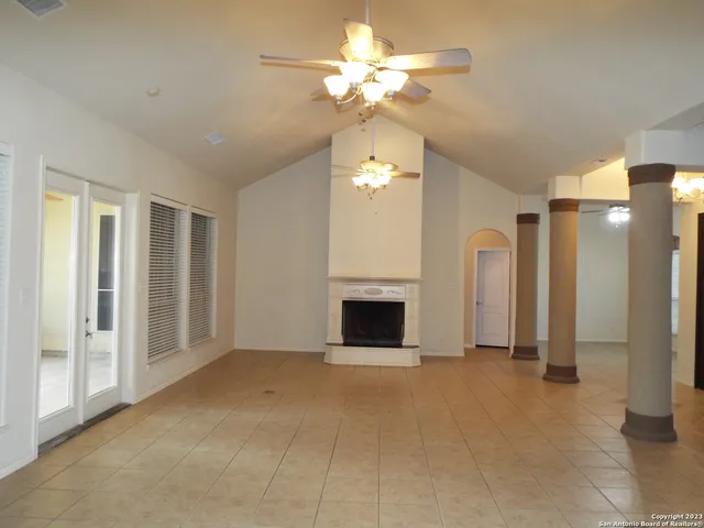 a view of a livingroom with a chandelier fan and a fireplace