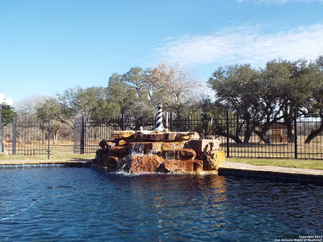 a view of a swimming pool with lake view and trees in the background