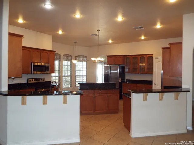 a kitchen with stainless steel appliances kitchen island granite countertop a stove and a sink
