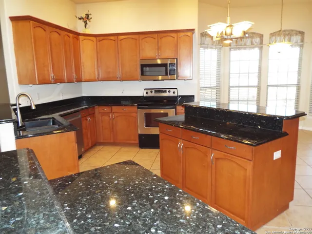 a kitchen with granite countertop a sink and a stove top oven