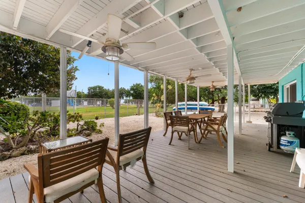 a view of a patio with dining table and chairs with wooden floor