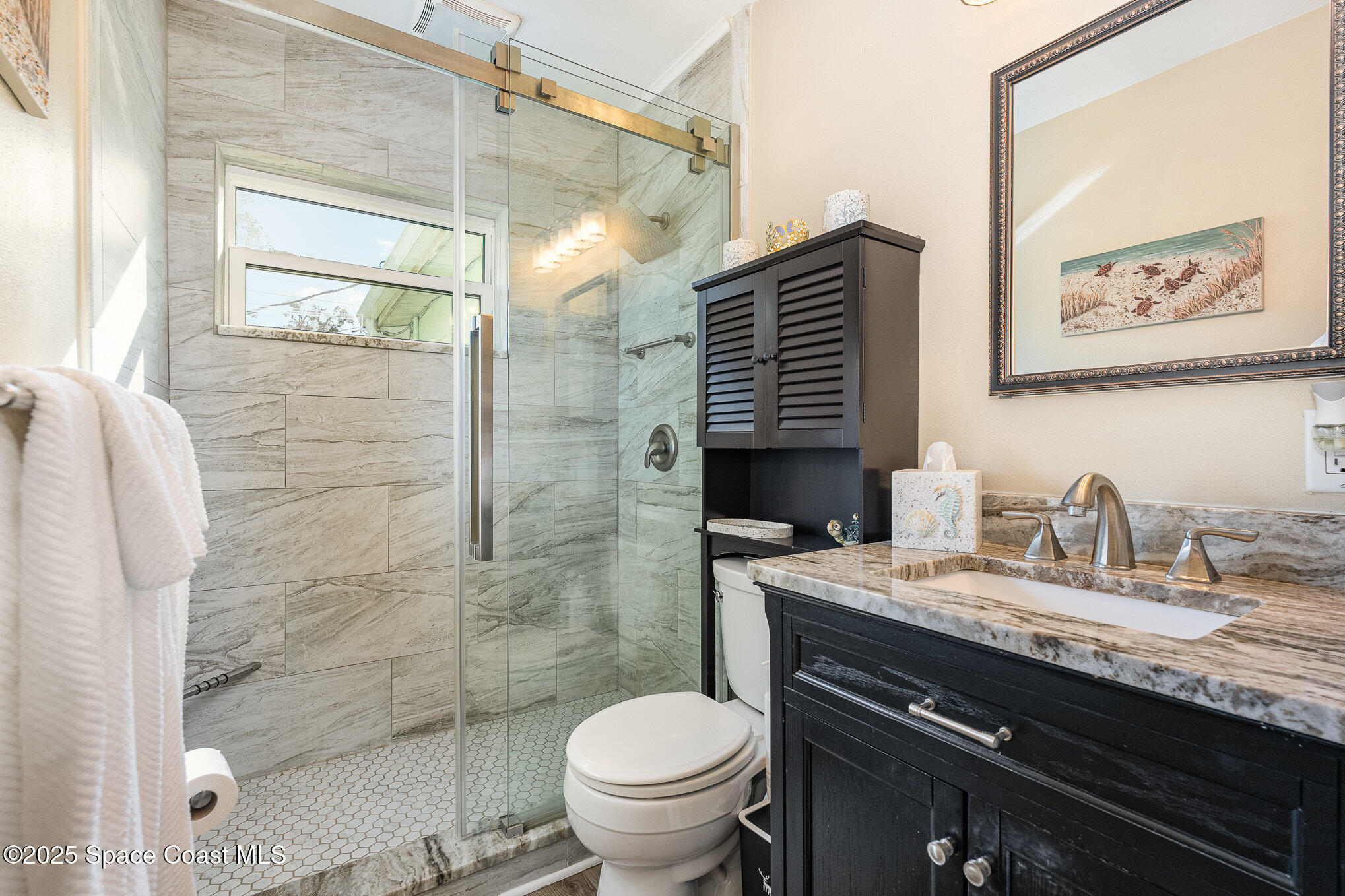 701 Espanola Way Melbourne, FL 32901 - Photo 17 of 29 a bathroom with a granite countertop sink toilet and shower