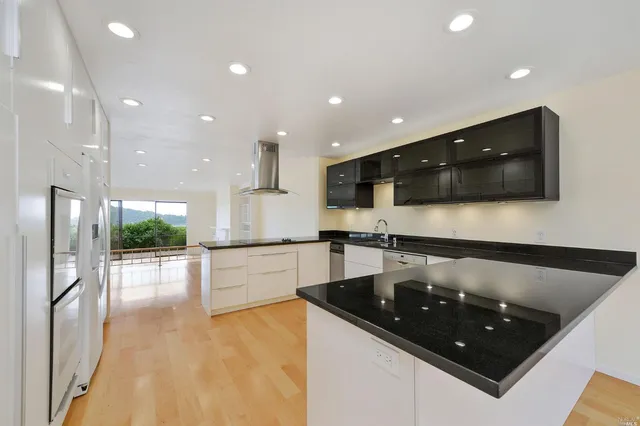 a kitchen with stainless steel appliances granite countertop a sink and a stove top oven