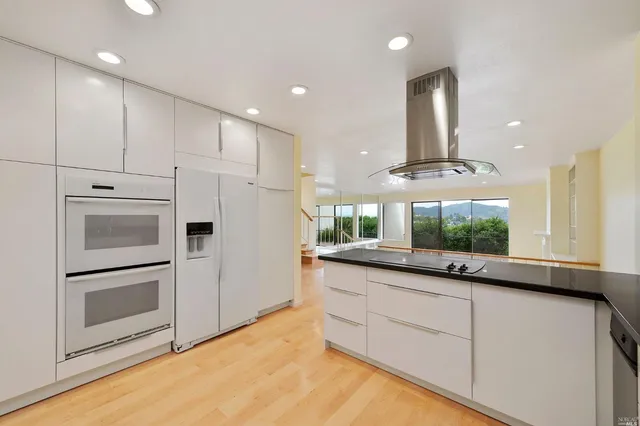 a kitchen with granite countertop white cabinets and white appliances