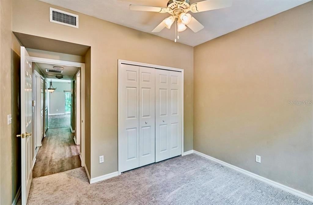 322 Northwest 50th Boulevard Gainesville, FL 32607 - Photo 13 of 19 an empty room with a ceiling fan and a mirror