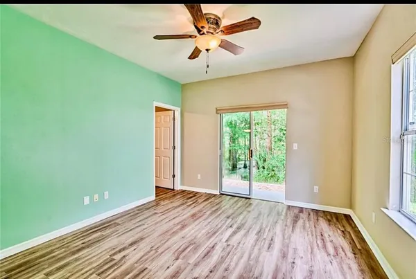 a view of an empty room with window and wooden floor