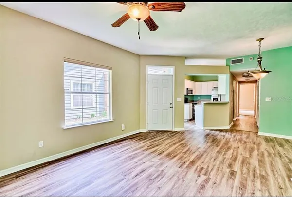 a view of a kitchen with a fridge wooden floor and a kitchen