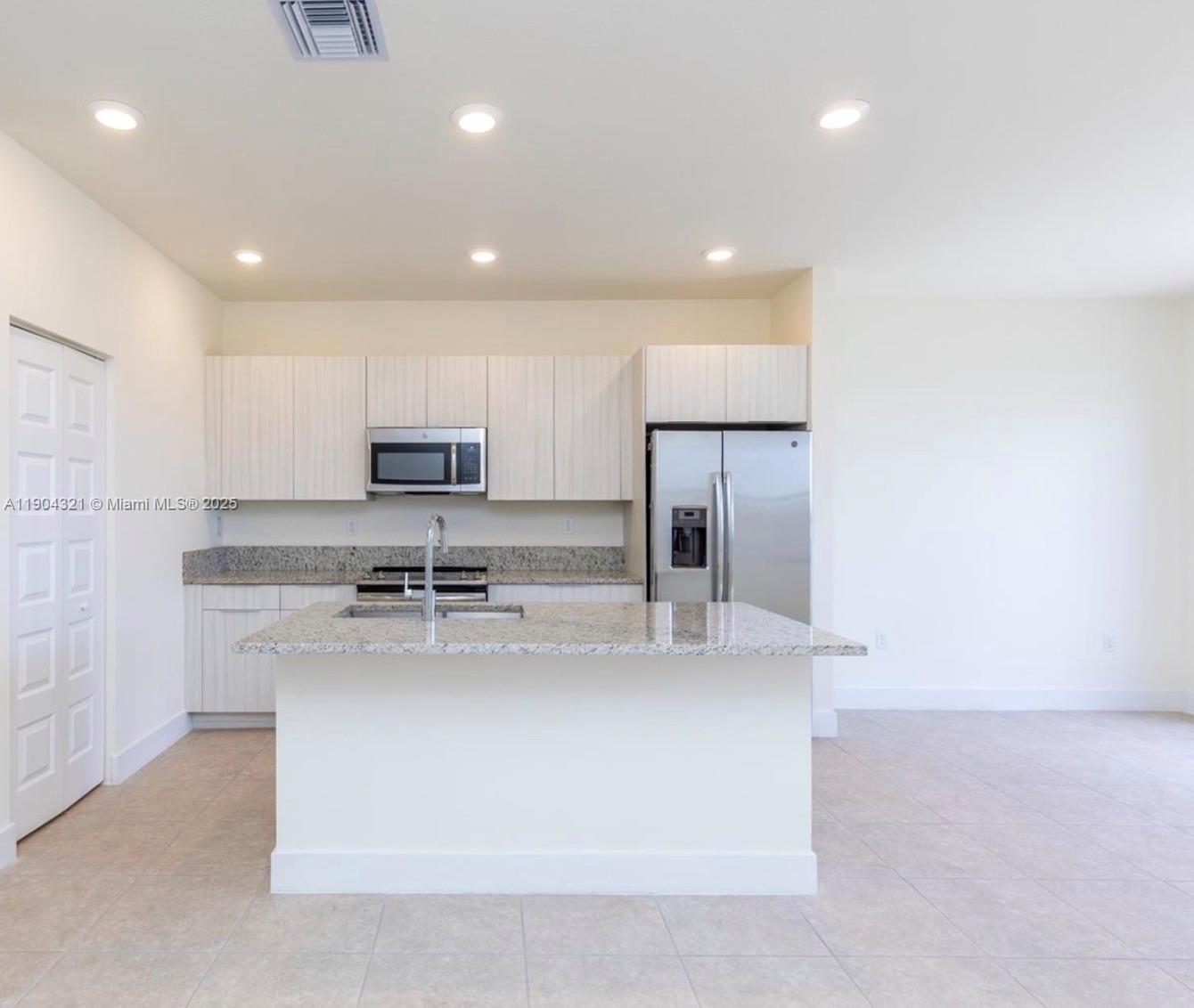 15861 Northwest 90th Court, Unit 15861 Miami Lakes, FL 33018 - Photo 13 of 31 a kitchen with stainless steel appliances granite countertop a sink a stove and a refrigerator