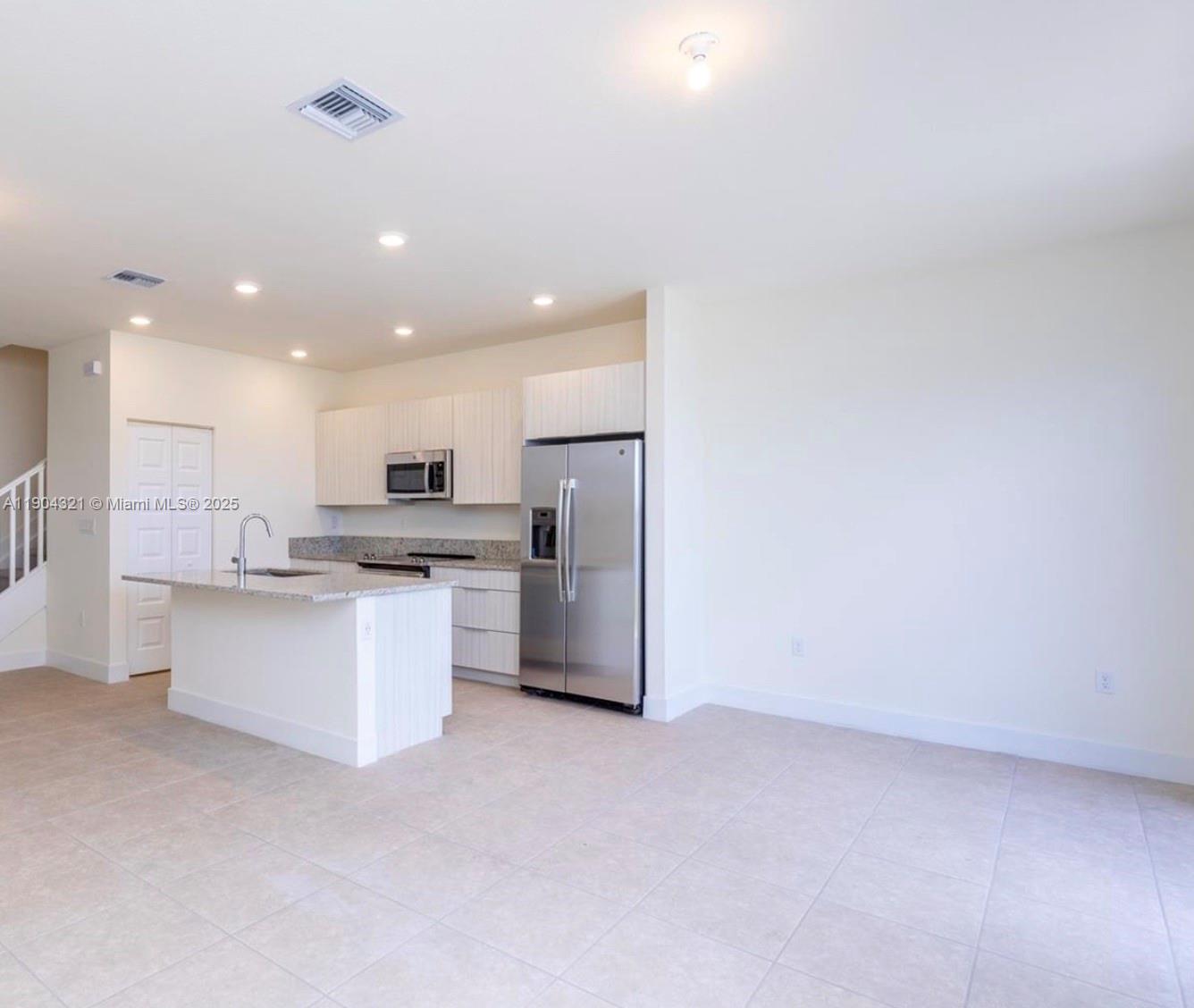 15861 Northwest 90th Court, Unit 15861 Miami Lakes, FL 33018 - Photo 14 of 31 a kitchen with white cabinets and refrigerator
