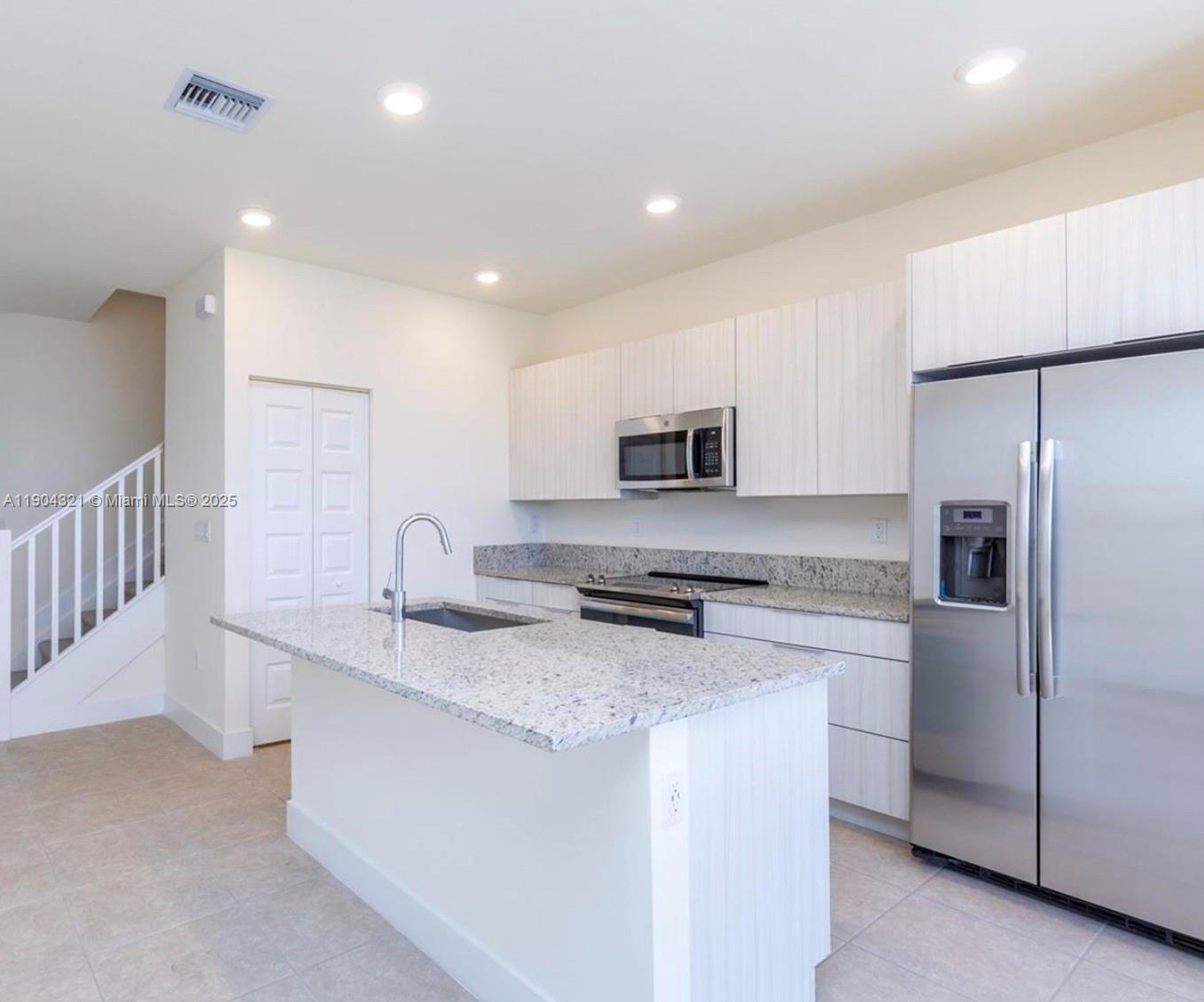 15861 Northwest 90th Court, Unit 15861 Miami Lakes, FL 33018 - Photo 17 of 31 a kitchen with stainless steel appliances granite countertop a sink and a refrigerator