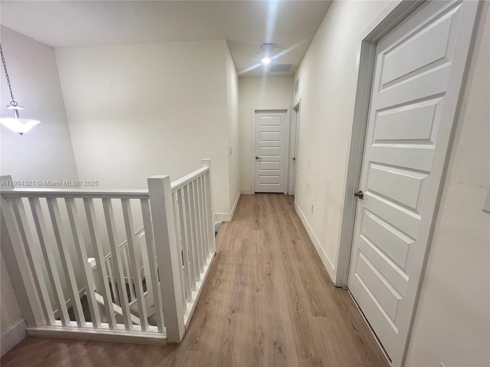 15861 Northwest 90th Court, Unit 15861 Miami Lakes, FL 33018 - Photo 27 of 31 a view of a hallway with wooden floor and staircase