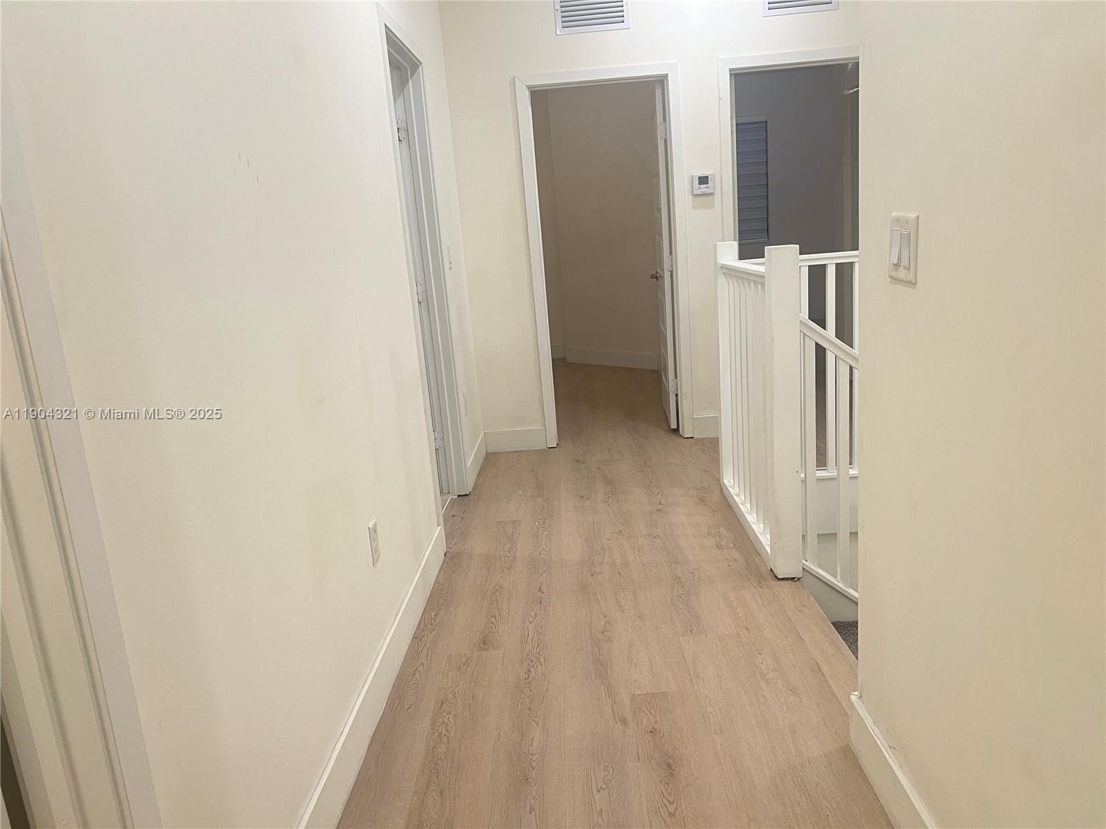 15861 Northwest 90th Court, Unit 15861 Miami Lakes, FL 33018 - Photo 28 of 31 a view of a hallway with wooden floor and staircase