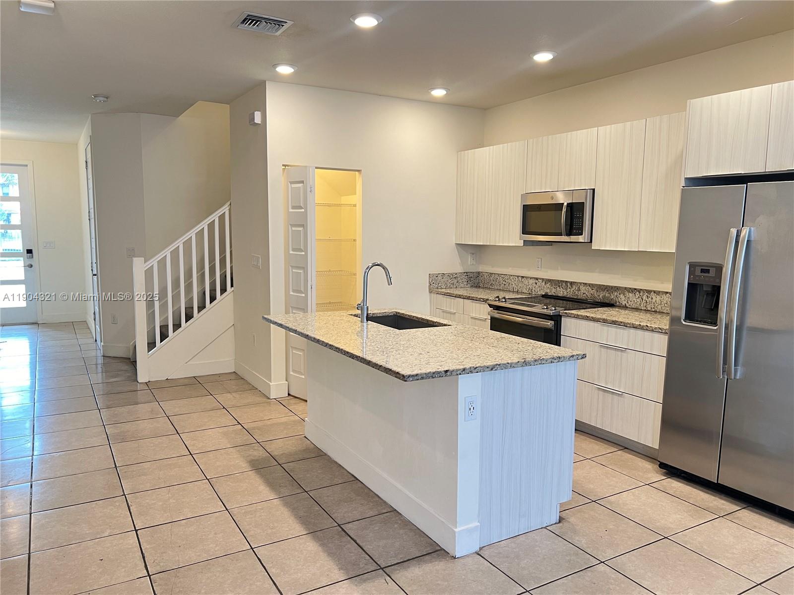15861 Northwest 90th Court, Unit 15861 Miami Lakes, FL 33018 - Photo 3 of 31 a kitchen that has a sink a microwave and a refrigerator