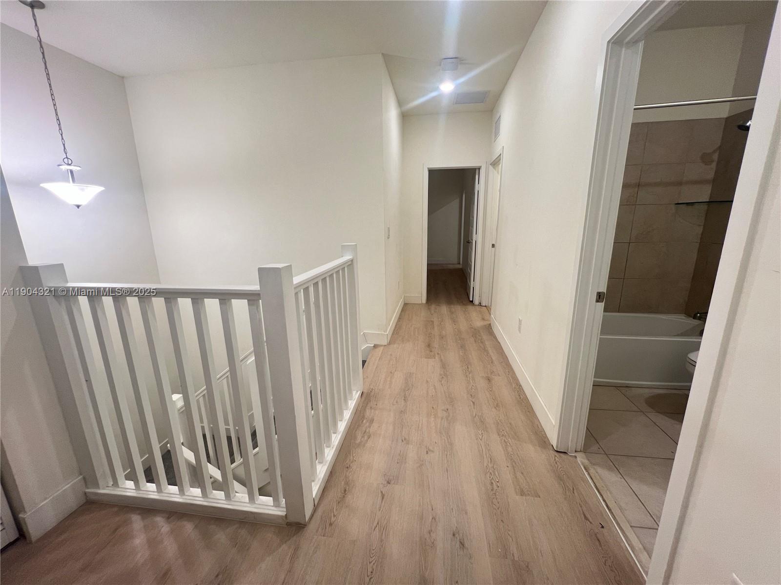 15861 Northwest 90th Court, Unit 15861 Miami Lakes, FL 33018 - Photo 31 of 31 a view of a hallway with wooden floor and staircase
