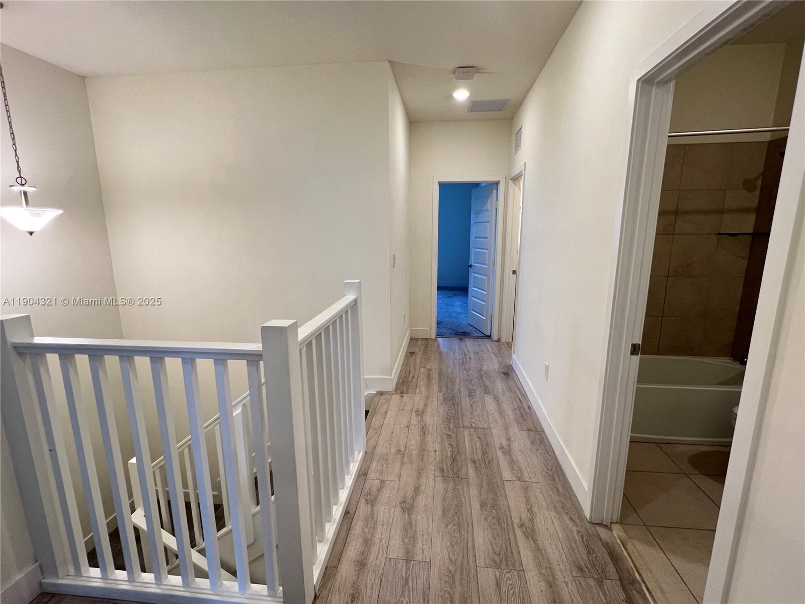 15861 Northwest 90th Court, Unit 15861 Miami Lakes, FL 33018 - Photo 7 of 31 a view of a hallway with wooden floor and staircase