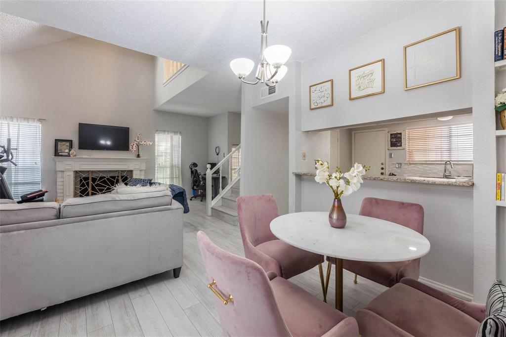 4050 Frankford Road, Unit 908 Dallas, TX 75287 - Photo 14 of 16 Dining area with wood-finish flooring, a contemporary chandelier, and a breakfast bar featuring a granite-look countertop
