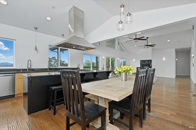 a kitchen with stainless steel appliances granite countertop a table chairs and a refrigerator