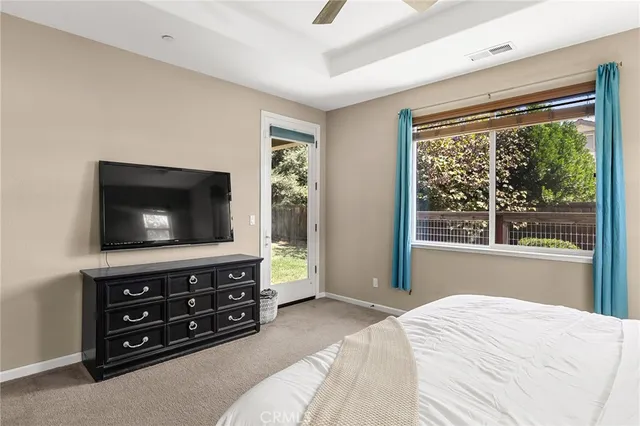 a bedroom with a bed and a flat tv screen on dresser