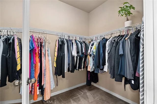 a view of walk in closet with clothes