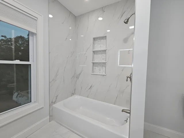 a bathroom with a bathtub and a shower