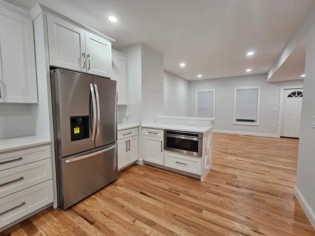 a kitchen with stainless steel appliances granite countertop a refrigerator and a stove top oven