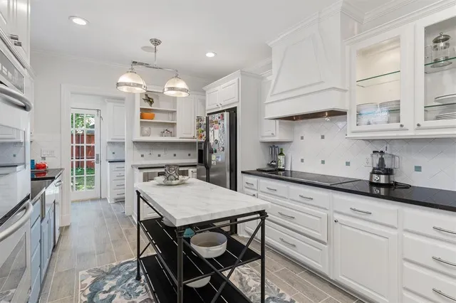 a kitchen with granite countertop a sink stove and refrigerator