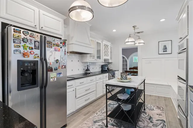 a kitchen with stainless steel appliances a sink a stove a refrigerator and cabinets