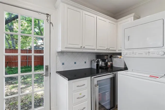 a kitchen with white cabinets and window