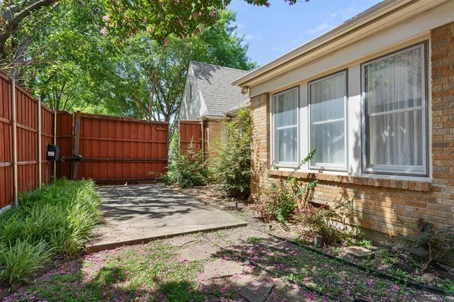 a view of backyard with table and chairs and wooden fence