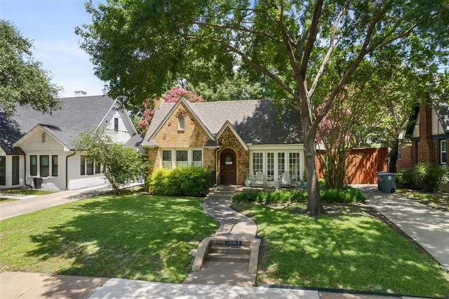 a front view of a house with a yard and trees
